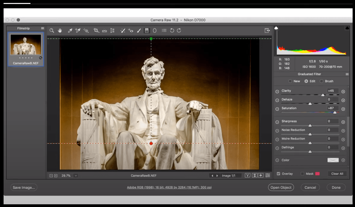 In the image shown, which Camera Raw feature was used to restrict the graduated filter to avoid the statue?